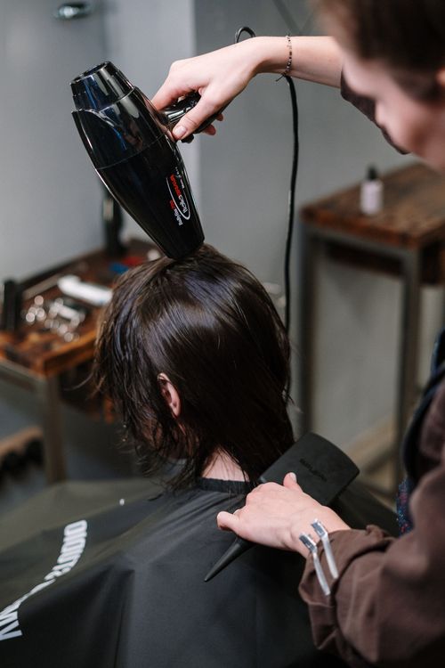 Estilista secando el cabello de una clienta
